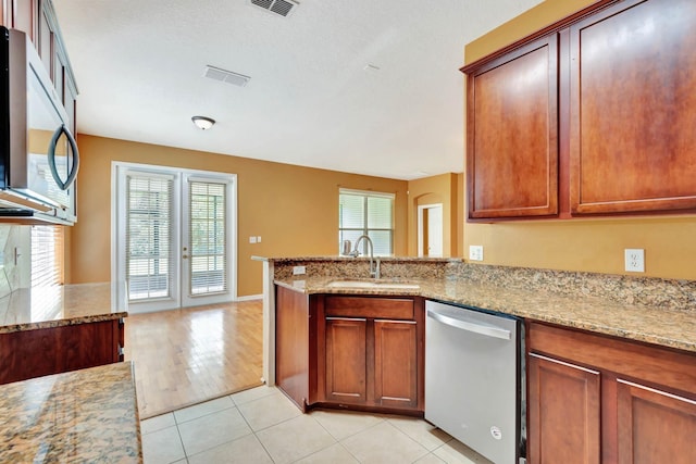 902 Heron Point Cir, Deland, FL 32724 - kitchen with stainless steel appliances, a sink, light stone counters, and a peninsula