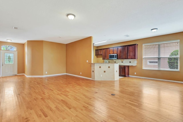 902 Heron Point Cir, Deland, FL 32724 - unfurnished living room with light wood-style flooring and baseboards