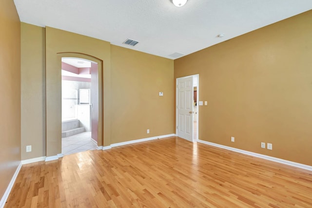 902 Heron Point Cir, Deland, FL 32724 - empty room with light wood-style floors, arched walkways, and baseboards