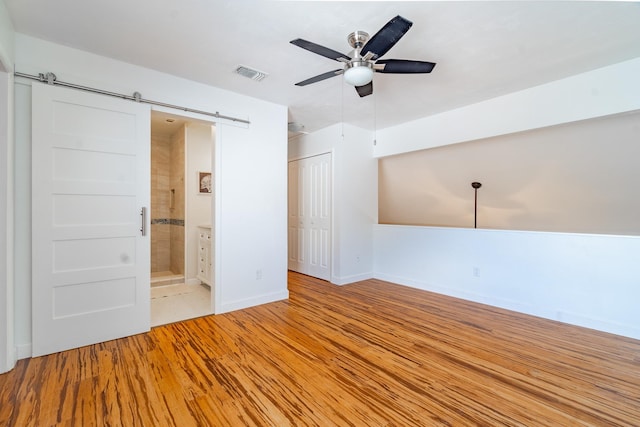 4602 Sandcastle Cir, Saint Augustine, FL 32084 - spare room featuring light wood finished floors, a ceiling fan, visible vents, baseboards, and a barn door
