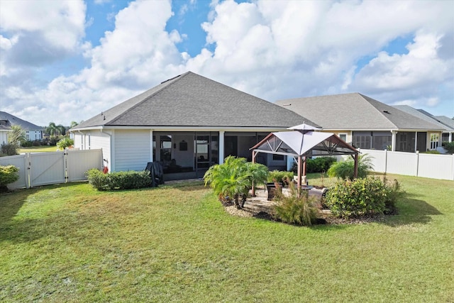 back of property with a lawn and a sunroom