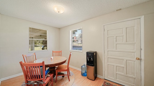 11519 W Confederate Dr, Glen Saint Mary, FL 32040 - dining area featuring baseboards, a textured ceiling, and light wood-style flooring