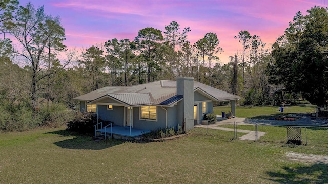 11519 W Confederate Dr, Glen Saint Mary, FL 32040 - view of front of house featuring a front lawn, fence, metal roof, a chimney, and a gate