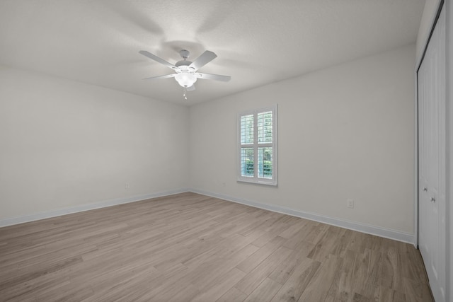 spare room with light wood-style flooring, baseboards, and ceiling fan