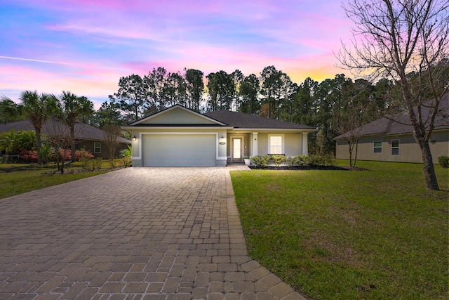 single story home with stucco siding, an attached garage, decorative driveway, and a front lawn