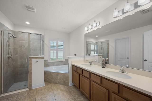 full bath featuring visible vents, double vanity, a stall shower, a bath, and a sink