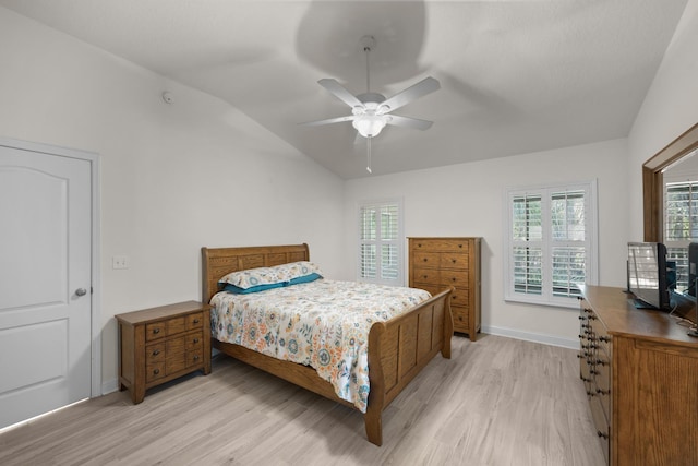 bedroom featuring baseboards, lofted ceiling, light wood-style flooring, and a ceiling fan