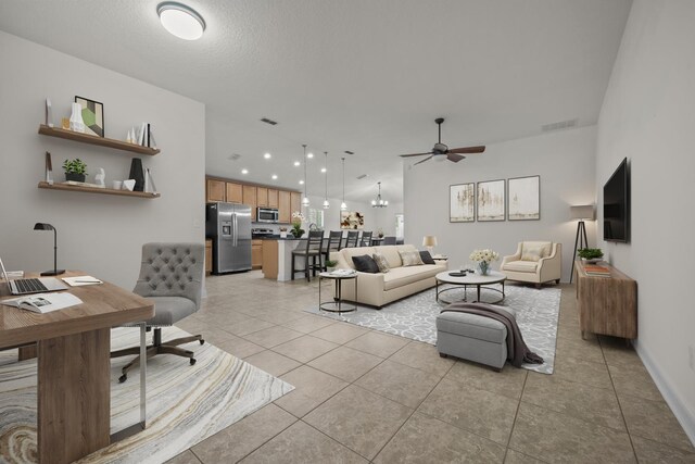 living area featuring light tile patterned floors, visible vents, and ceiling fan