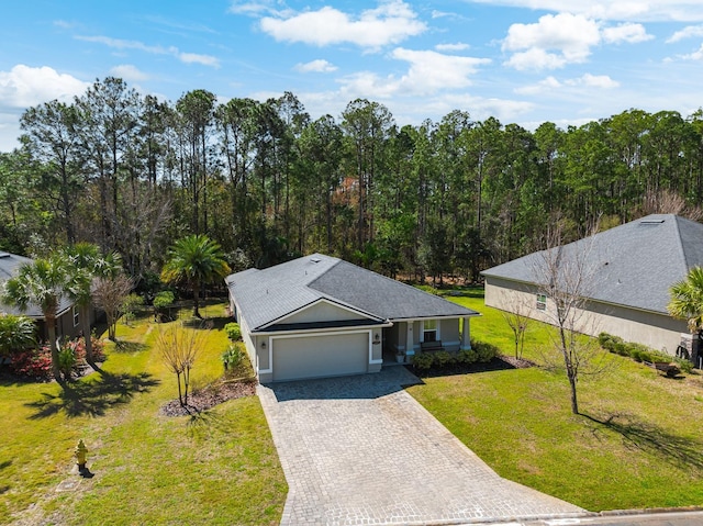 view of front of house with a front yard, decorative driveway, and a garage