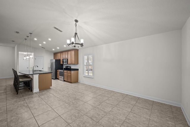 kitchen with visible vents, a sink, dark countertops, appliances with stainless steel finishes, and a chandelier