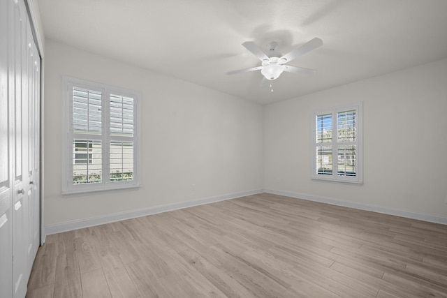 unfurnished room featuring baseboards, light wood-type flooring, and ceiling fan