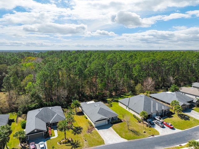 drone / aerial view featuring a residential view and a wooded view