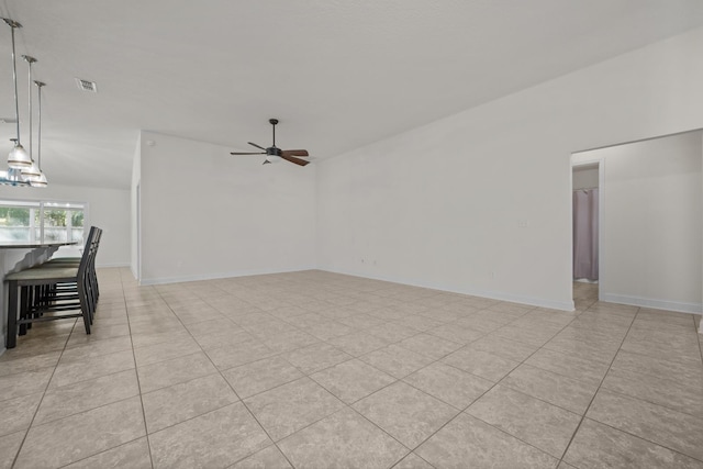 interior space featuring light tile patterned floors, baseboards, visible vents, and ceiling fan