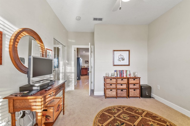 interior space with ceiling fan and light carpet