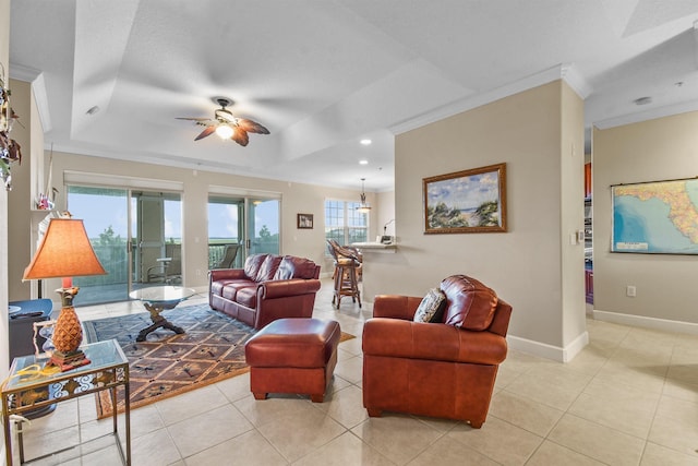 living room with a raised ceiling, ceiling fan, light tile patterned floors, and ornamental molding