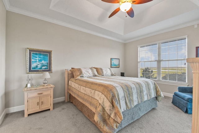 bedroom featuring a raised ceiling, ceiling fan, crown molding, and light colored carpet