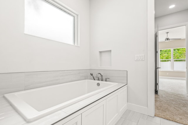 bathroom with a bath and tile patterned flooring