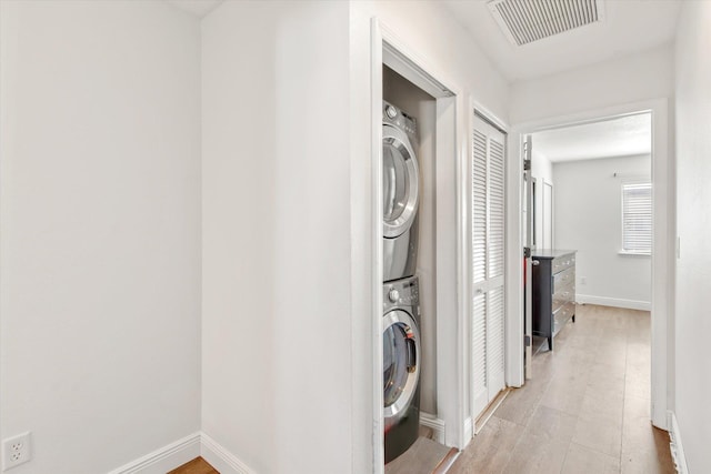 clothes washing area featuring stacked washer and dryer