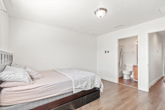 bedroom featuring hardwood / wood-style floors, ensuite bathroom, a spacious closet, and a closet