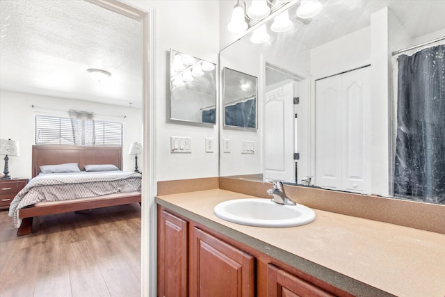 bathroom with vanity, a textured ceiling, and hardwood / wood-style flooring