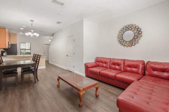 living room with an inviting chandelier and hardwood / wood-style flooring