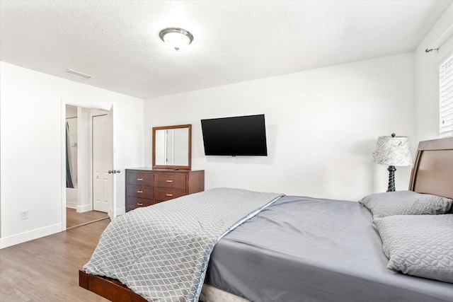 bedroom featuring a textured ceiling and hardwood / wood-style flooring