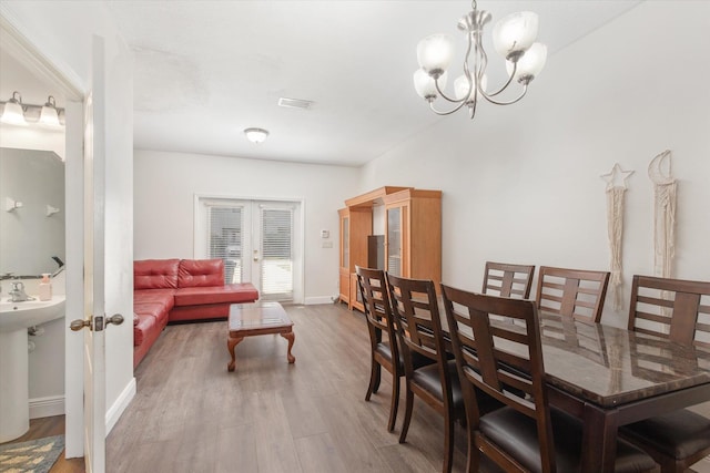 dining area featuring french doors, a notable chandelier, and hardwood / wood-style flooring