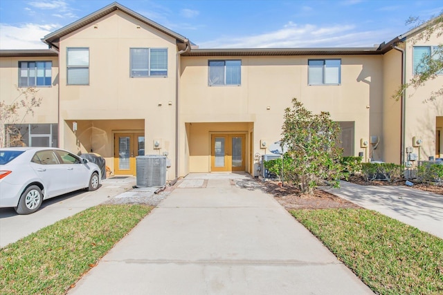 townhome / multi-family property featuring central air condition unit and french doors