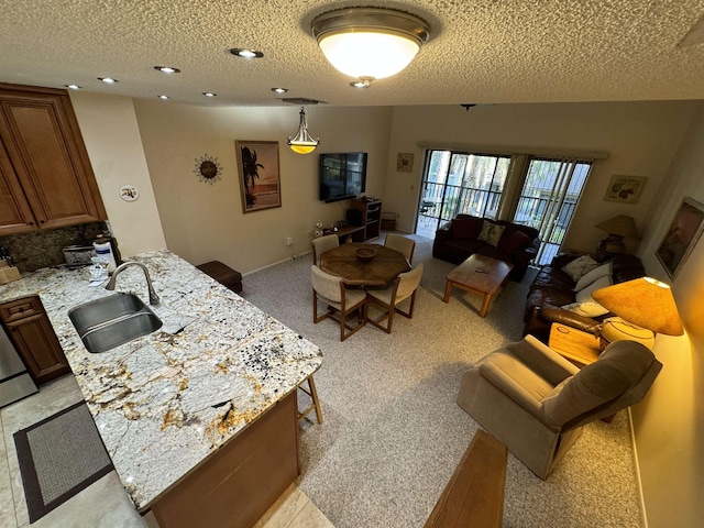 carpeted living room with a textured ceiling and sink