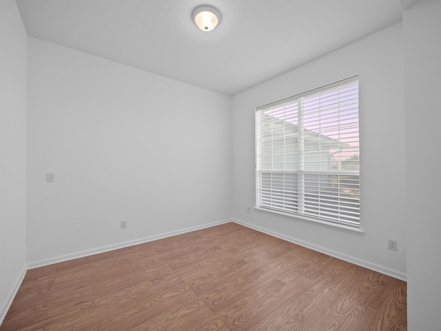 empty room featuring light wood-style flooring and baseboards