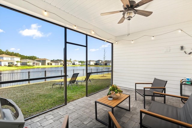 sunroom featuring a water view and ceiling fan