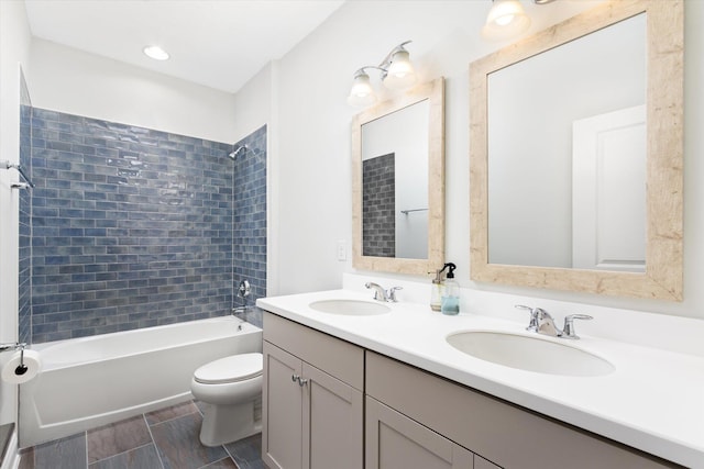 full bathroom with tiled shower / bath, vanity, and toilet