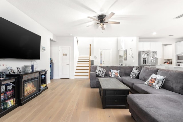 living room with ceiling fan and light hardwood / wood-style floors