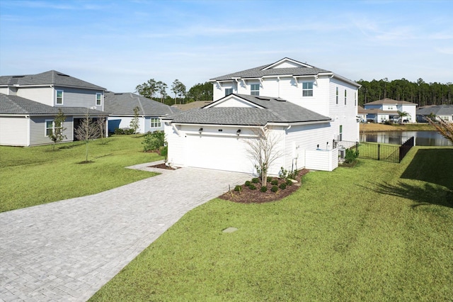 view of property with a garage, a front lawn, and a water view