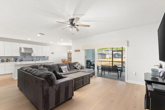 living room with ceiling fan and light wood-type flooring