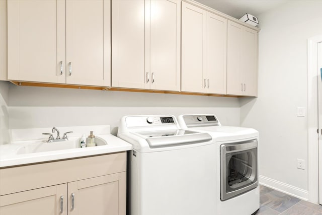 laundry room featuring cabinets, sink, and washer and clothes dryer