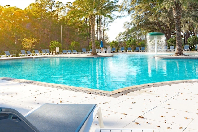 view of swimming pool featuring pool water feature and a patio