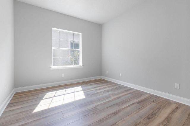 empty room with baseboards and light wood-type flooring