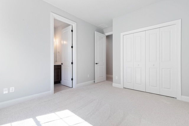 unfurnished bedroom with connected bathroom, a closet, visible vents, carpet floors, and baseboards
