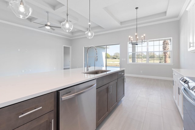kitchen with a raised ceiling, a sink, light countertops, stainless steel appliances, and coffered ceiling