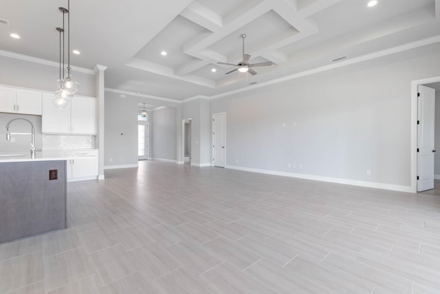 unfurnished living room featuring ornamental molding, a ceiling fan, recessed lighting, a sink, and coffered ceiling