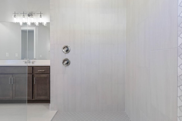 bathroom featuring tiled shower, tile patterned flooring, and vanity