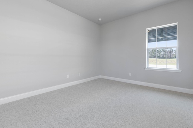 unfurnished room with carpet floors and baseboards