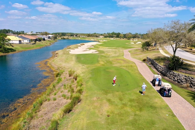 birds eye view of property with view of golf course and a water view