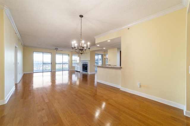 unfurnished living room with a textured ceiling, crown molding, hardwood / wood-style floors, and ceiling fan with notable chandelier