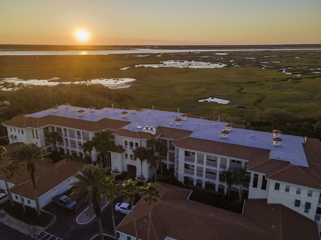 aerial view at dusk featuring a water view