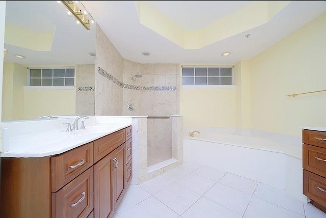 bathroom with tile patterned floors, vanity, a raised ceiling, tile walls, and plus walk in shower