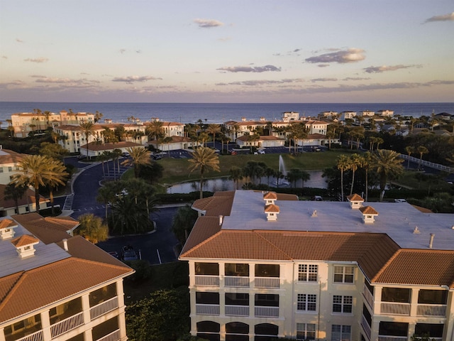 aerial view at dusk featuring a water view