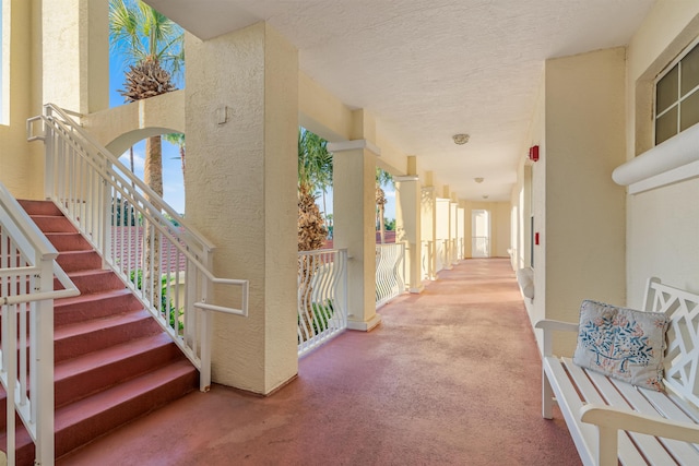 corridor featuring plenty of natural light, carpet floors, and a textured ceiling