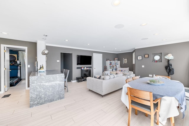 interior space featuring baseboards, visible vents, light wood-style flooring, recessed lighting, and ornamental molding